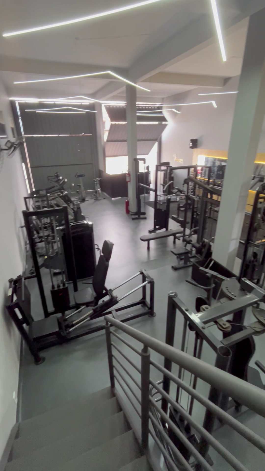 Vista elevada do piso de treino da Academia Portal Fit, com equipamentos de cardio e musculação.